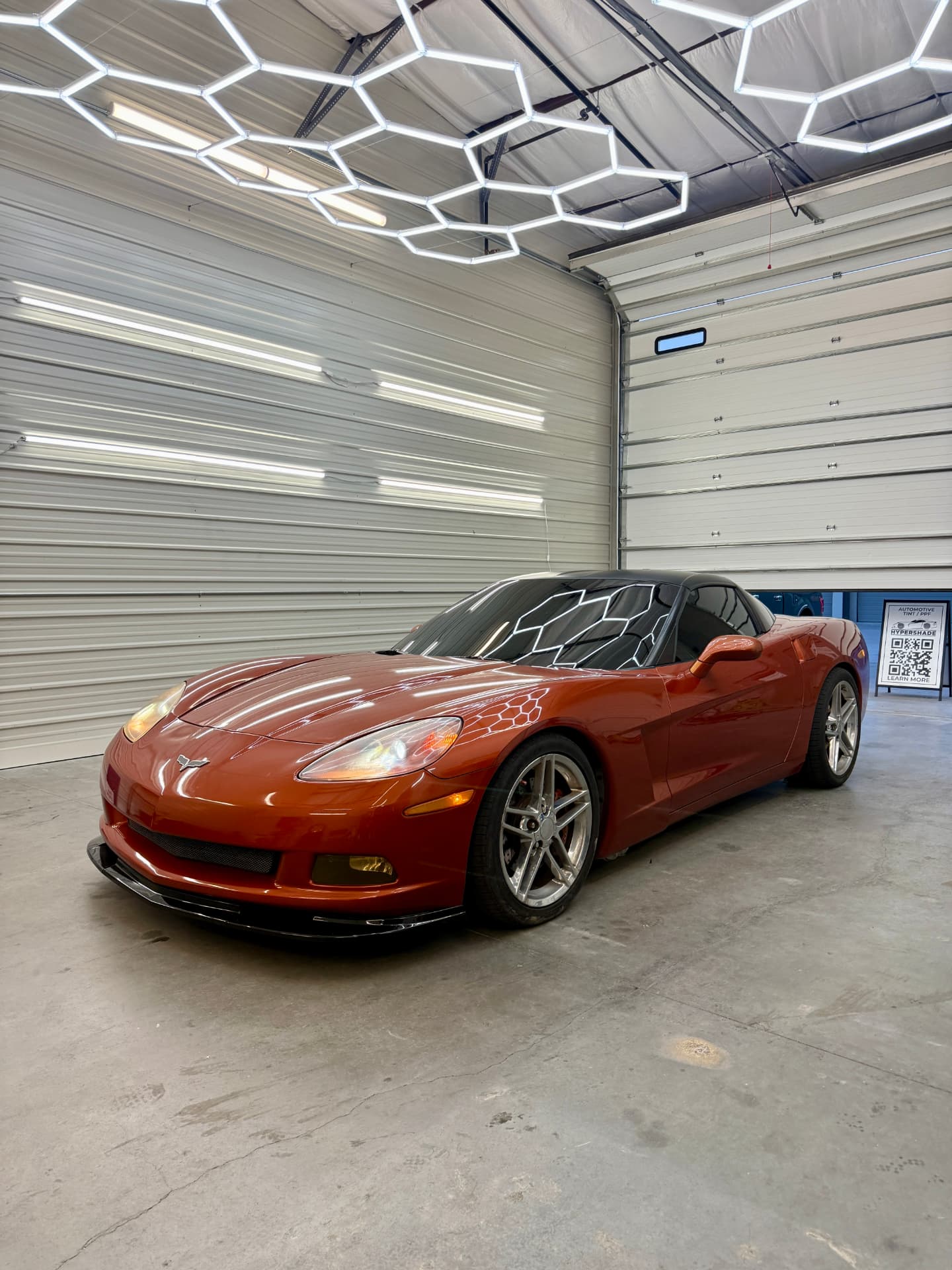 Orange Corvette with freshly installed ceramic window tint in the Hypershade install bay